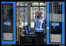 Amsterdam, zast�vka tramvaj� Centraal Station. D�ma kontroluj�c� cestovn� l�stky p�i n�stupu do vozidla.